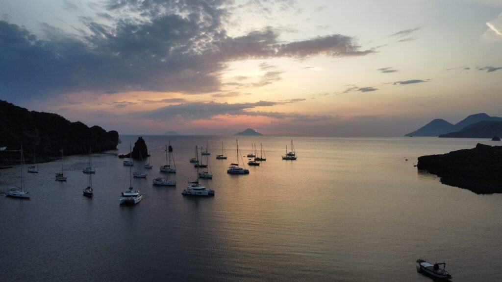 Czartery jachtów - kilka jachtów na tle zachodzącego słońca